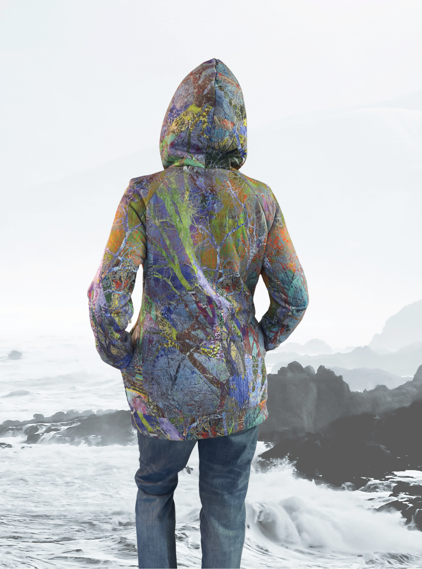 Person wearing a colorful hooded jacket standing on a snowy landscape